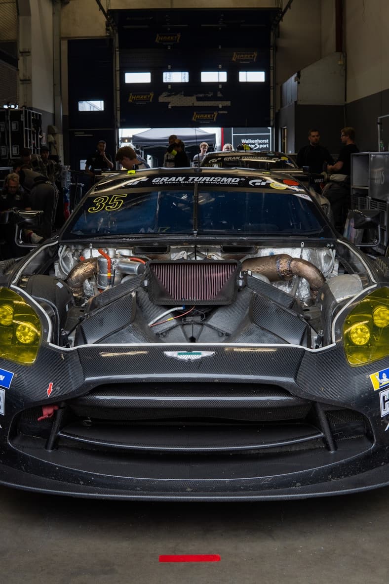 Hand pouring fluid from bottle into engine using blue funnel